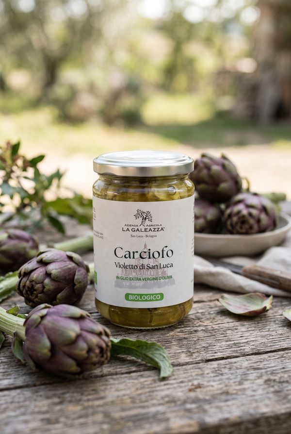 Barattolo di carciofi Violetto di San Luca sott'olio biologici de La Galeazza, tra carciofi freschi su un tavolo di legno